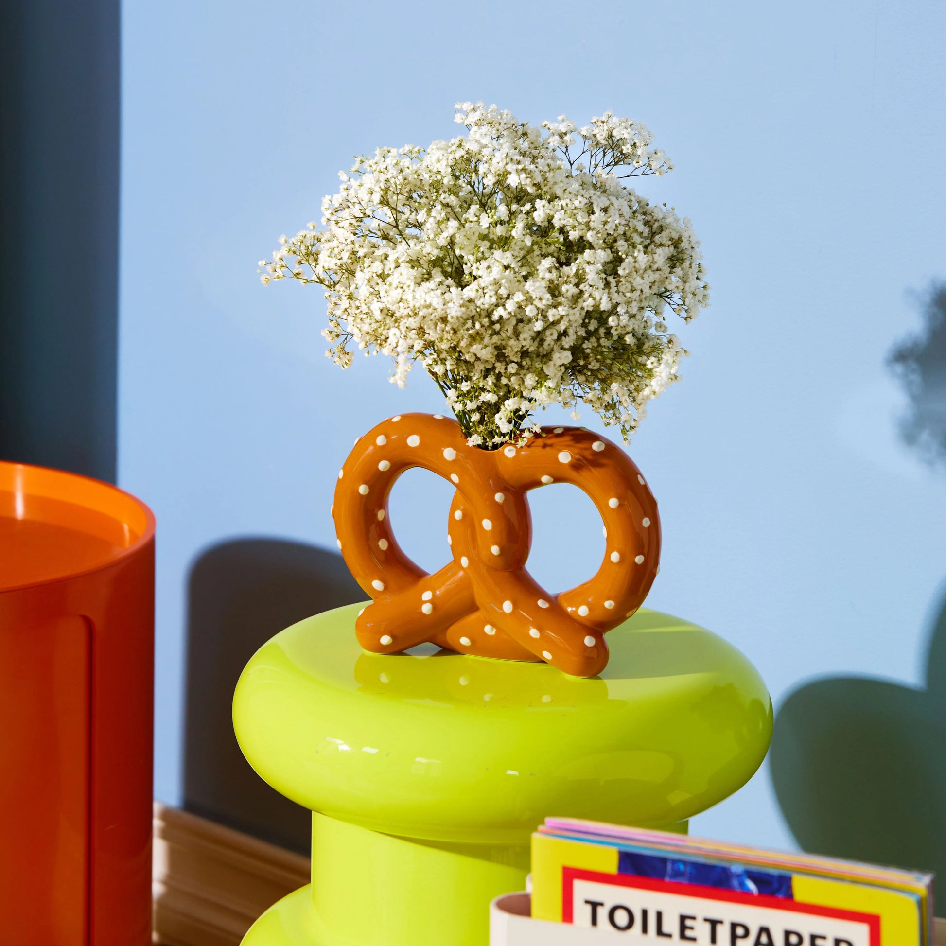 Vase en céramique en forme de bretzel marron avec des pois blancs.