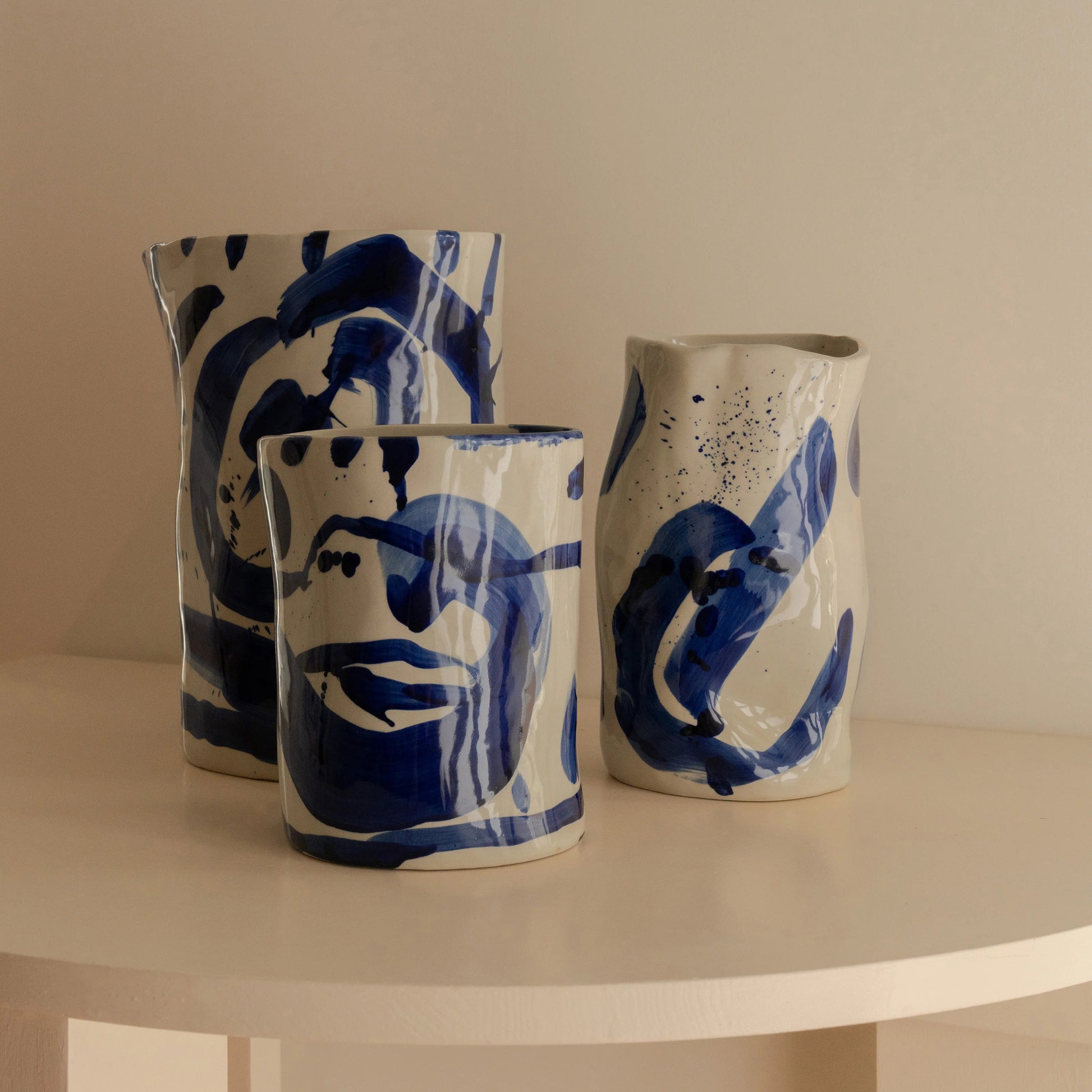 Trio de vases en céramique à la forme irrégulière et peint à la main dans un bleu indigo.