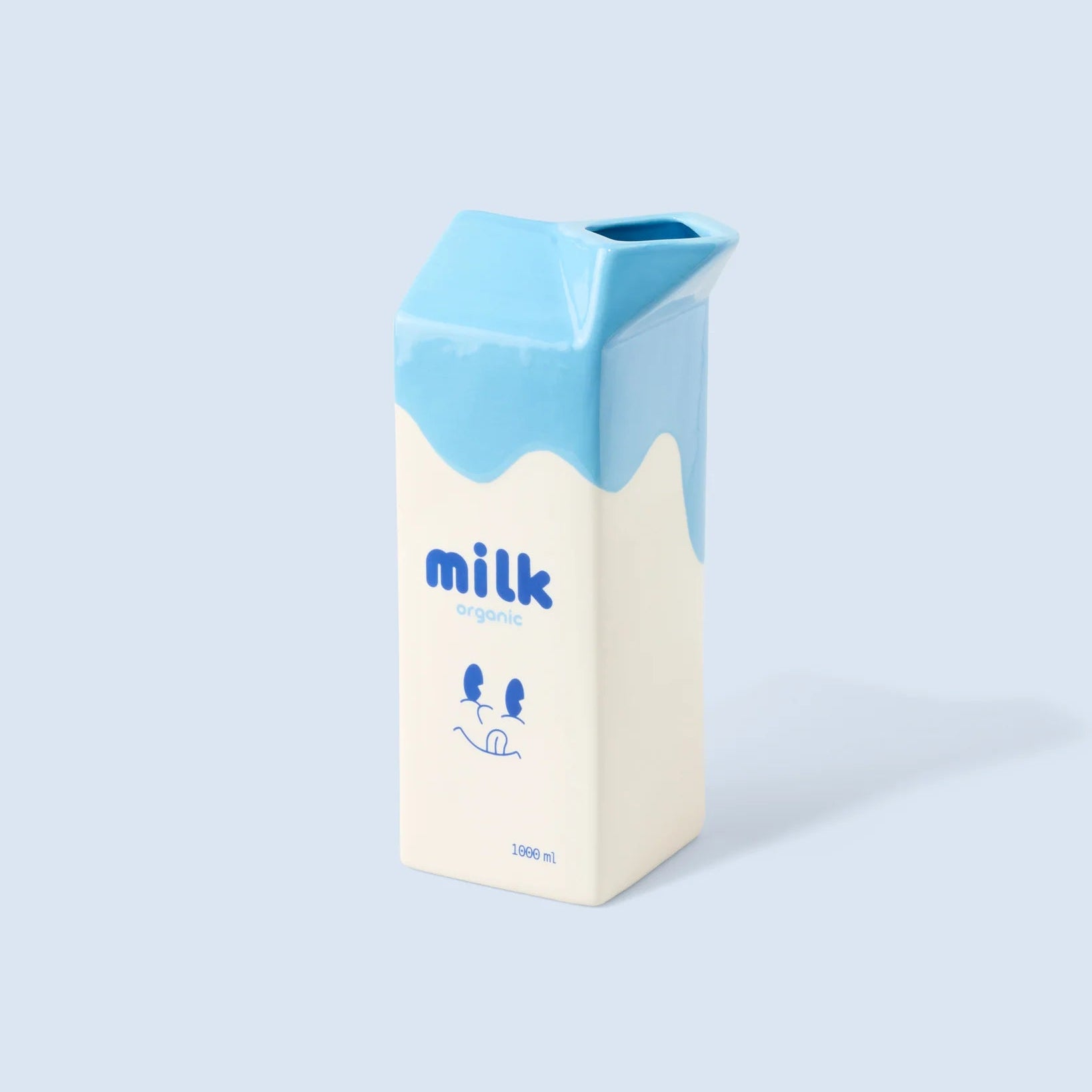 Vase en céramique en forme de brique de lait, coloris blanc et bleu.