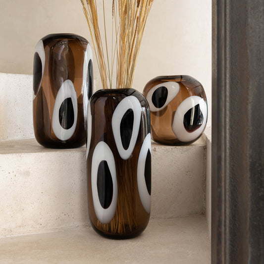 Composition de vases en verre marron, blanc et noir et de forme ovale. 