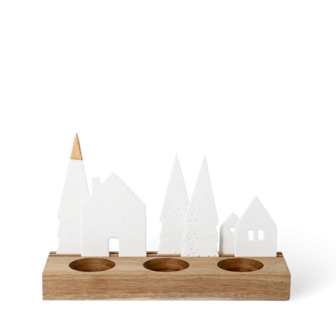 Village de Noël en porcelaine ponctué de doré sur socle en bois rainuré. 