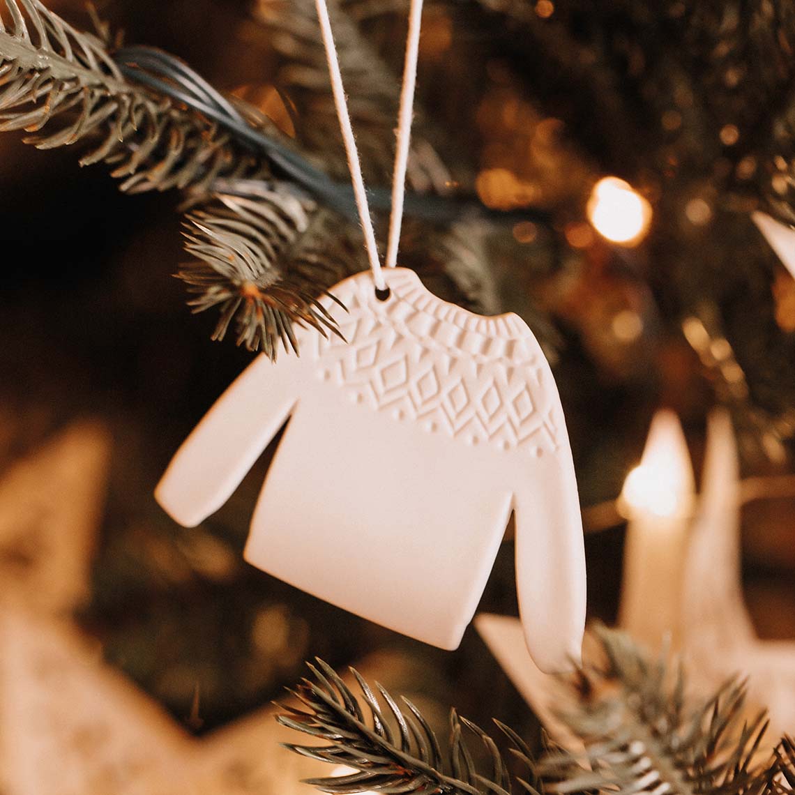 Décoration de Noël à suspendre en forme de pull-over en porcelaine blanche. 