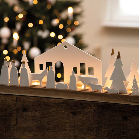 Crèche en porcelaine avec tous ses sujets en porcelaine sur plateau en bois rainuré.
