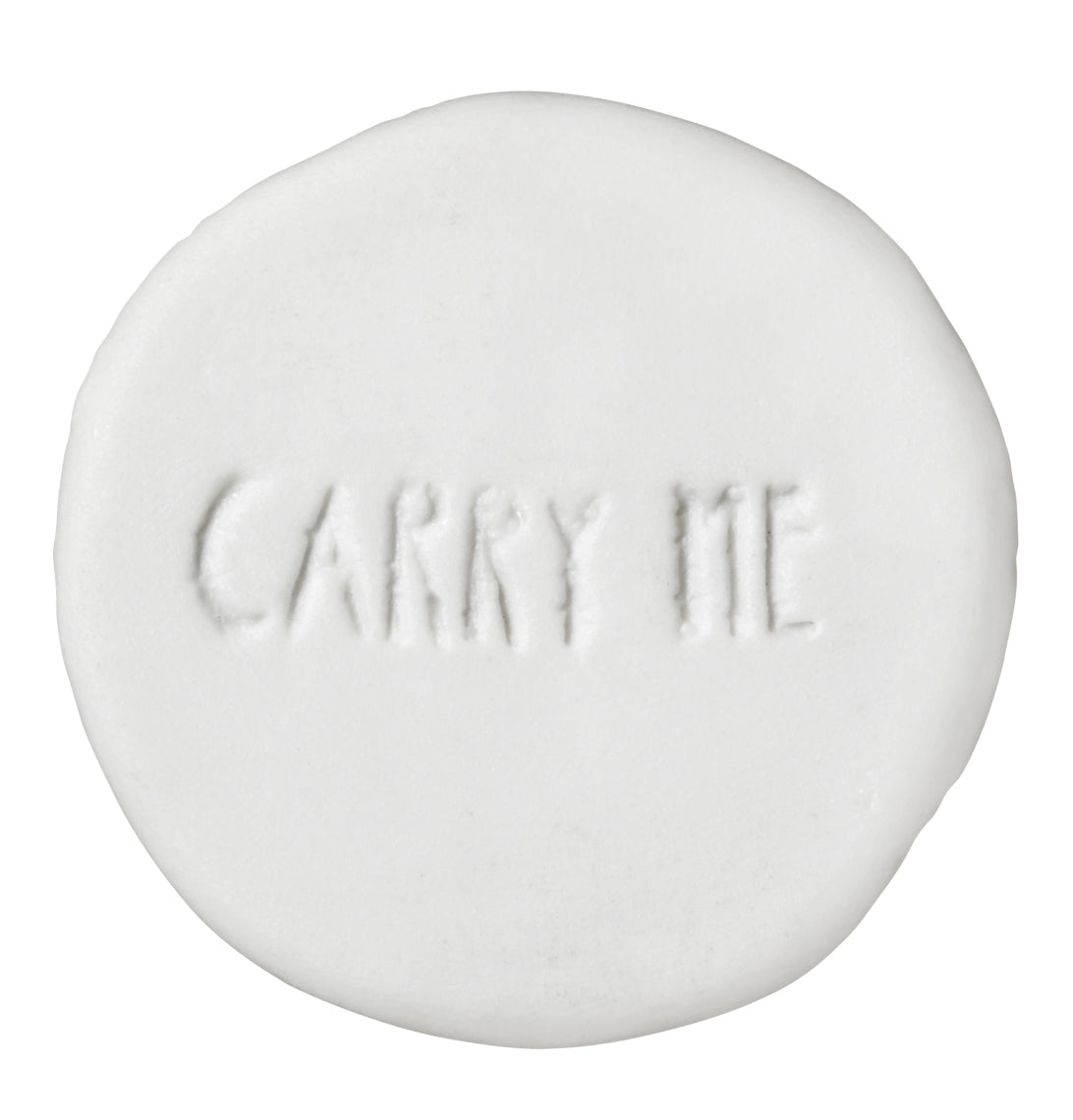 Verso d'une petite pièce porte-bonheur en porcelaine blanche avec typographie gravée "Carry me"